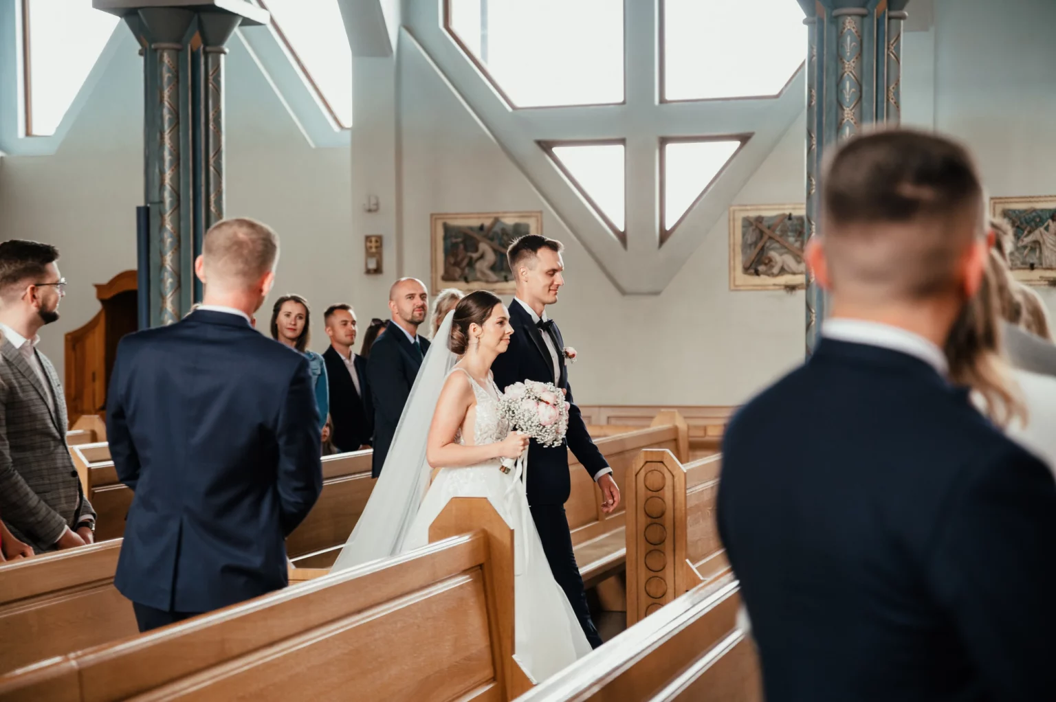 Karolina i Sebastian — powitanie w kościelnej nawie.