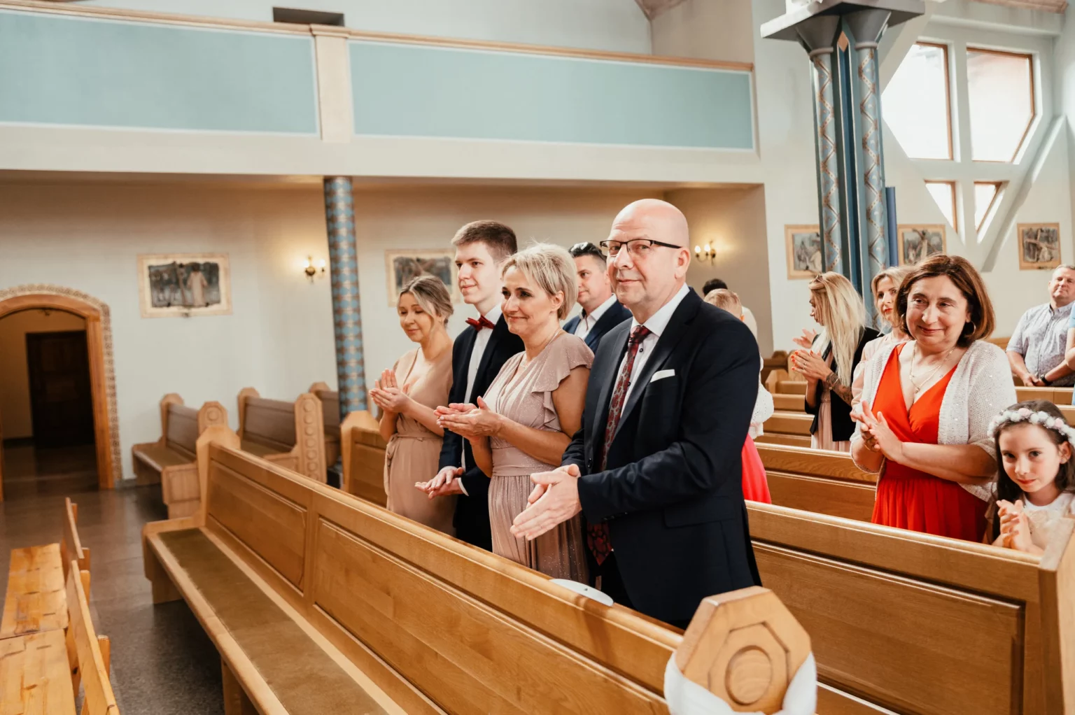 Karolina i Sebastian — goście siedzący w kościelnych ławach.