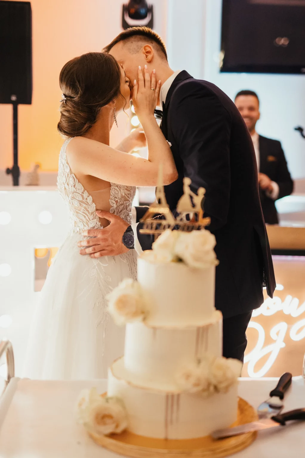 Karolina i Sebastian — pocałunek przy torcie weselnym.