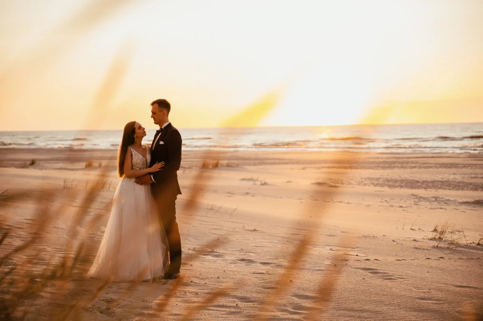 Karolina i Sebastian — taniec na plaży w ciepłym świetle.