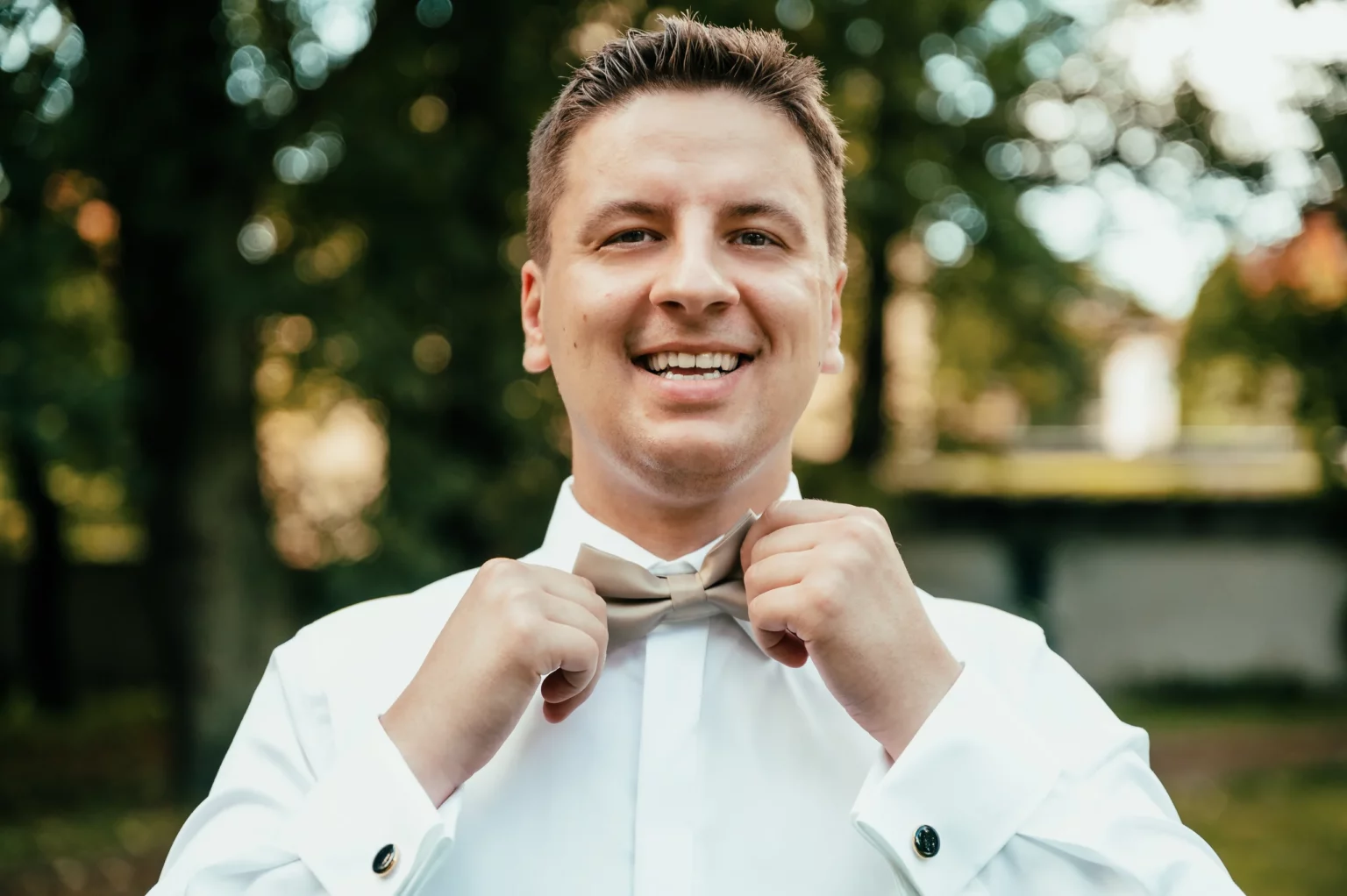 Kasia i Radek — pan młody poprawia muchę.