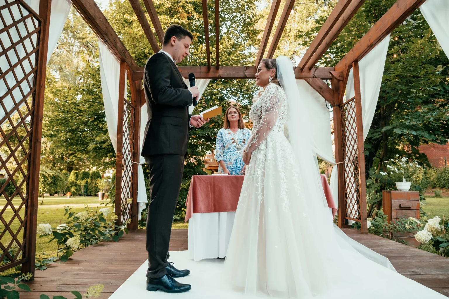 Kasia i Radek — ceremonia pod drewnianą altaną.