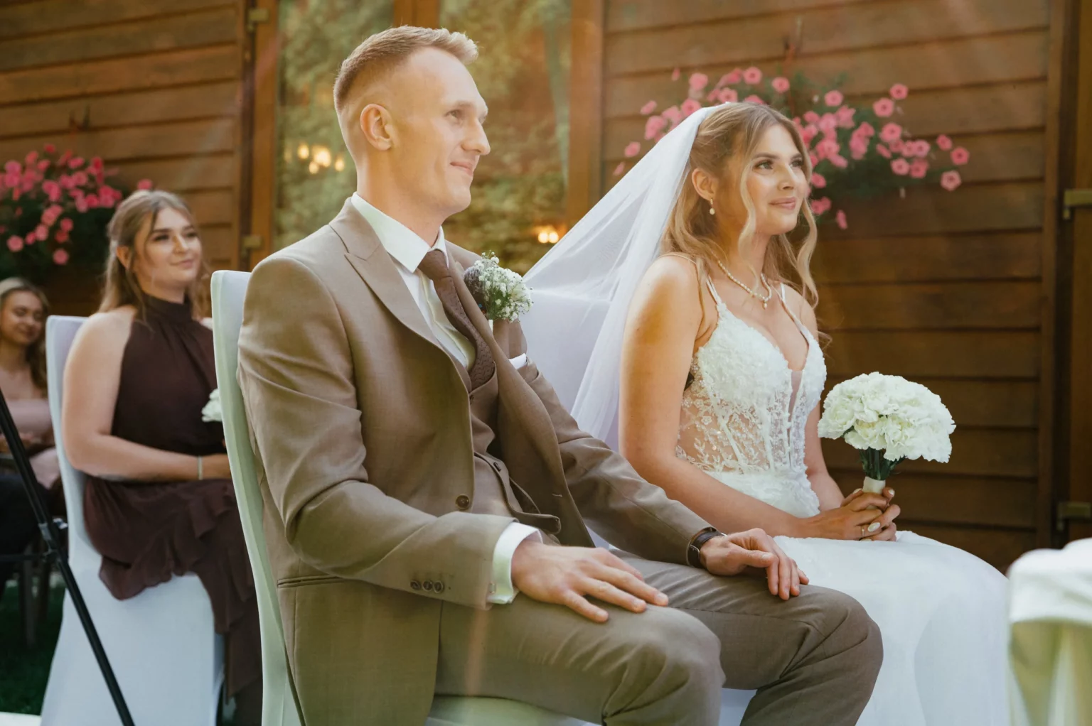 Nadia i Michał — para młoda siedzi podczas ceremonii.