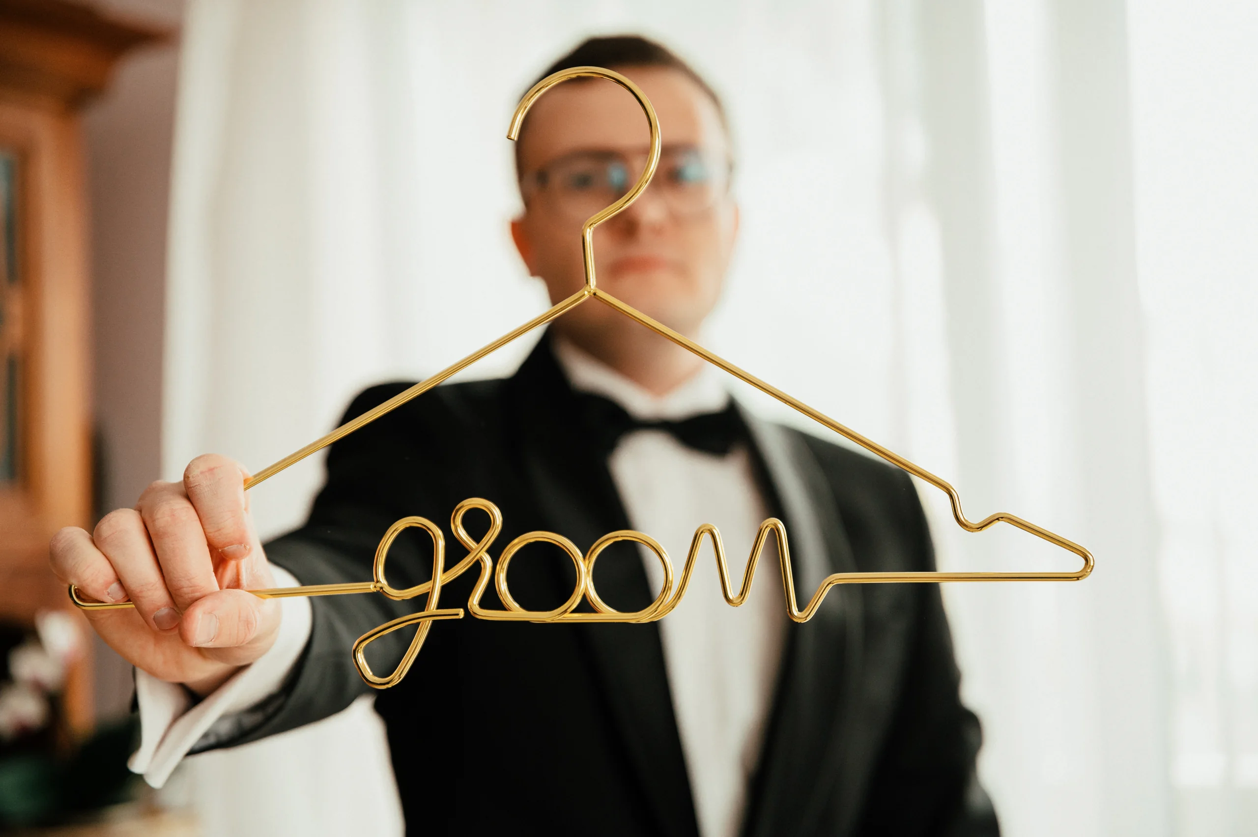 Pan młody z wieszakiem z napisem groom.