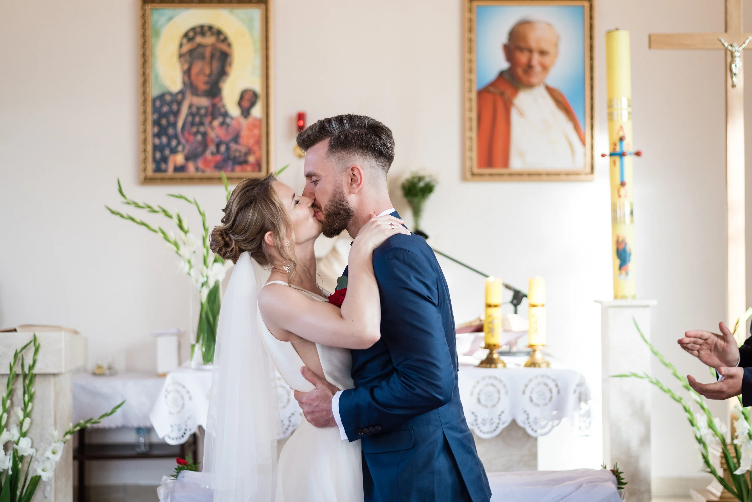 Para młoda całująca się podczas ceremonii w kościele.
