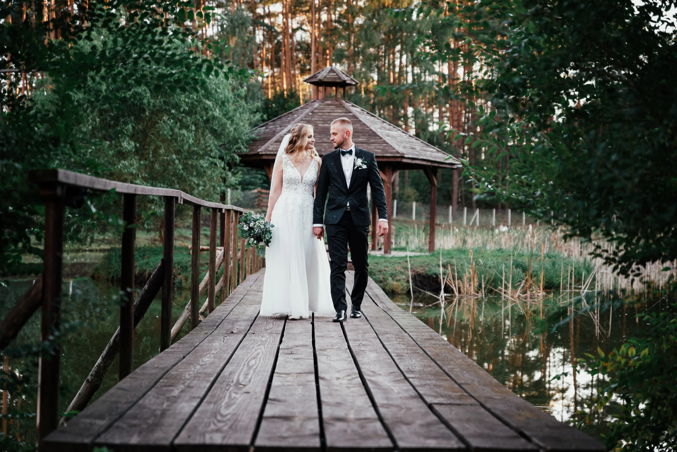Para młoda na drewnianym mostku wśród zieleni.